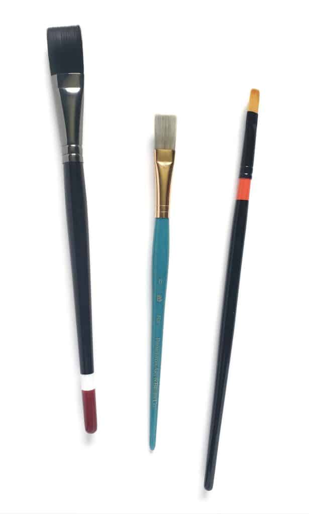 There is an image of three different sizes of flat watercolor brushes. The first is large, the second is medium, and the third is small.