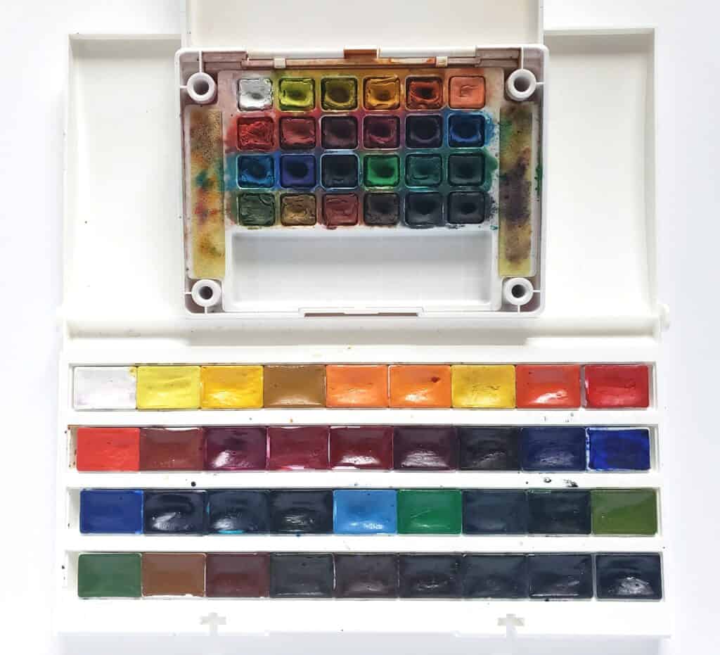 There is an image of two sets of watercolor pans. One set has 24 half-pans in a small palette whereas the second set has 36 whole pans in a large palette.